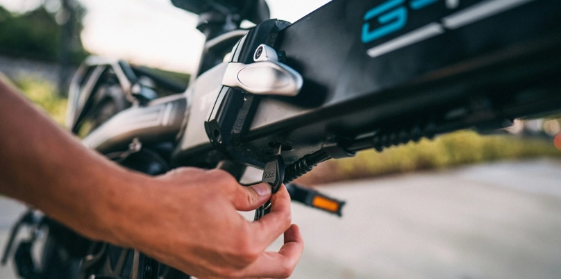 Eine Hand dreht einen Schlüssel an einem E-Bike.
